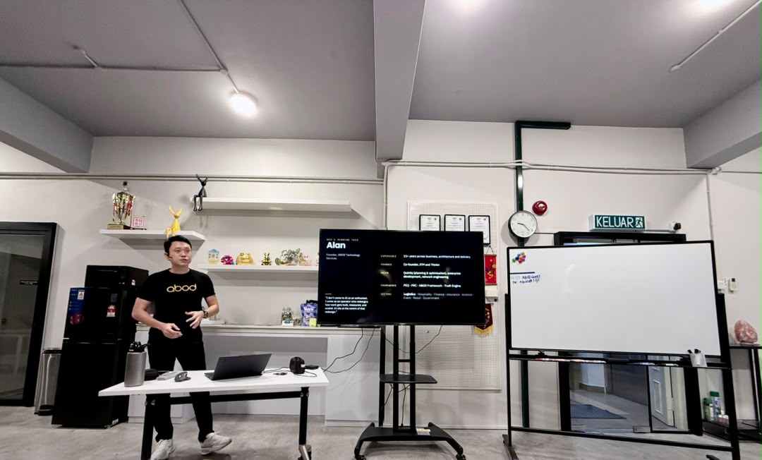 Alan Goh presenting in the ABOD training room, beside a screen listing his experience, frameworks and sectors
